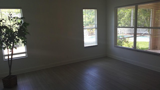 spare room featuring baseboards and wood finished floors