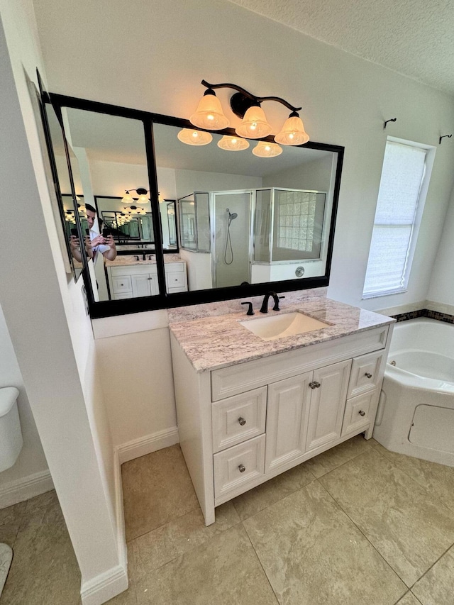 bathroom with a stall shower, a textured ceiling, a bath, and vanity