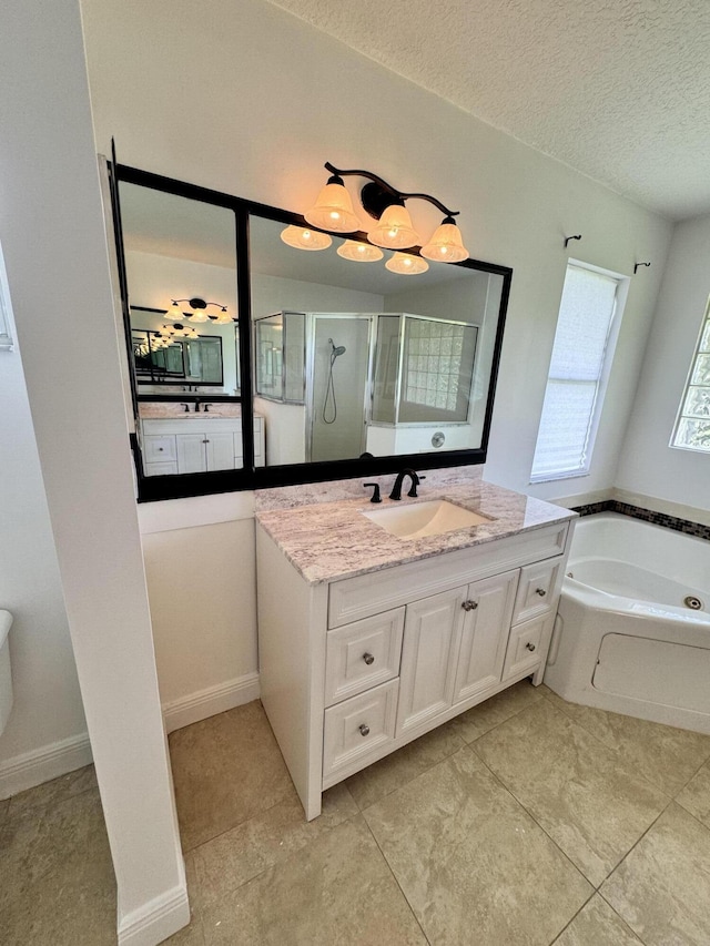 bathroom with a bath, a shower stall, vanity, and a textured ceiling