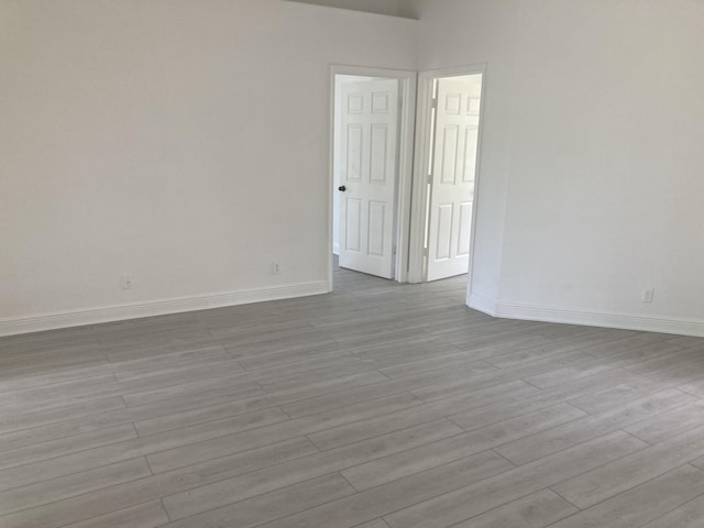 spare room with light wood-style flooring and baseboards