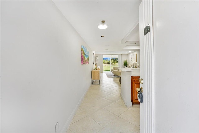 hall with light tile patterned floors and baseboards