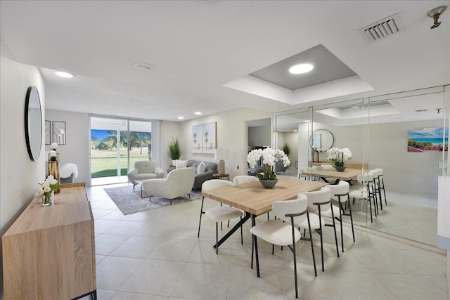 dining area featuring light tile patterned floors, visible vents, a tray ceiling, and recessed lighting