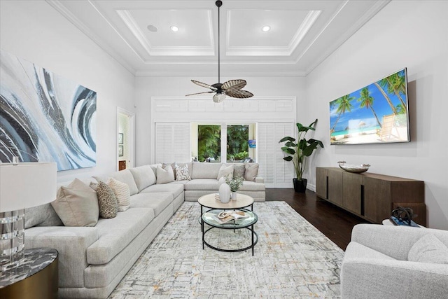 living area with beam ceiling, coffered ceiling, crown molding, and wood finished floors