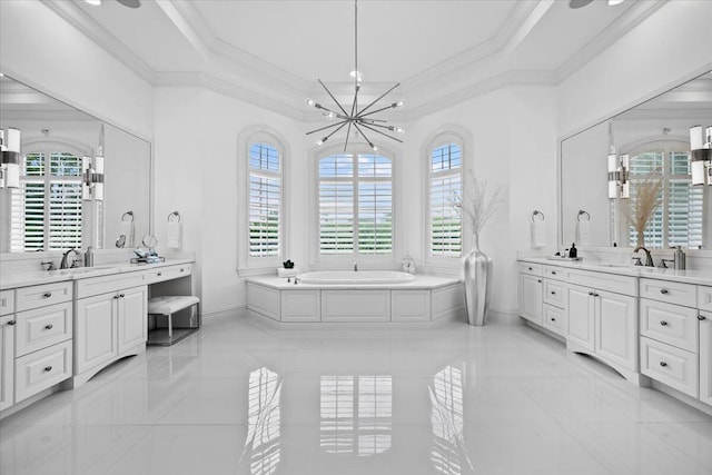 bathroom featuring crown molding, two vanities, a sink, baseboards, and a bath