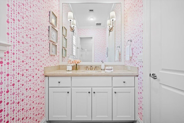 bathroom with visible vents, vanity, and wallpapered walls