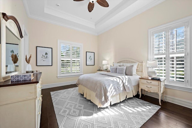 bedroom featuring a tray ceiling, dark wood-style flooring, multiple windows, and baseboards