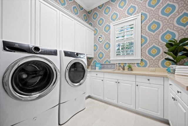 clothes washing area with wallpapered walls, cabinet space, a sink, crown molding, and washing machine and dryer