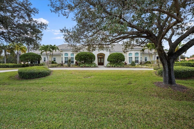 french country inspired facade featuring a front yard