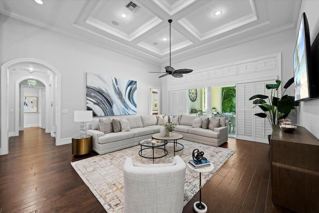 living room with visible vents, coffered ceiling, dark wood finished floors, ornamental molding, and a towering ceiling