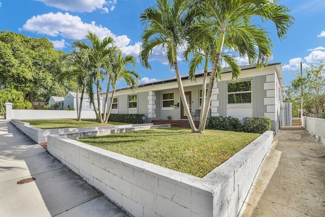 ranch-style house with fence and a front lawn