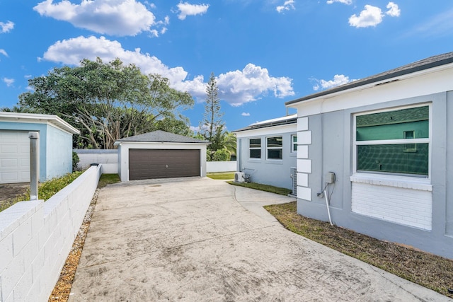 view of property exterior with an outbuilding, fence, and a garage