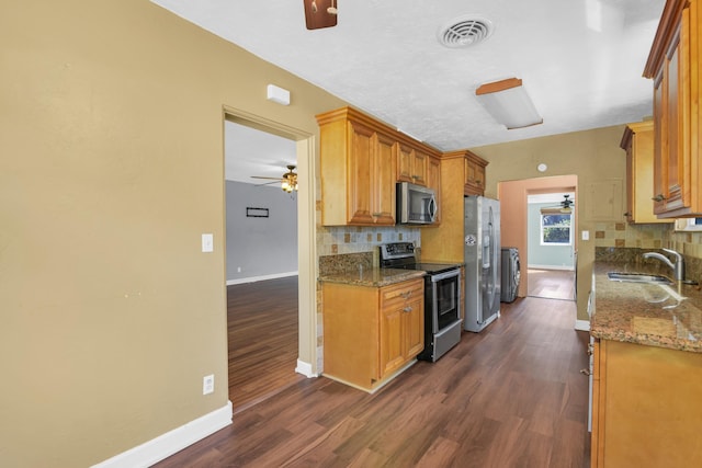 kitchen featuring separate washer and dryer, a sink, visible vents, a ceiling fan, and appliances with stainless steel finishes