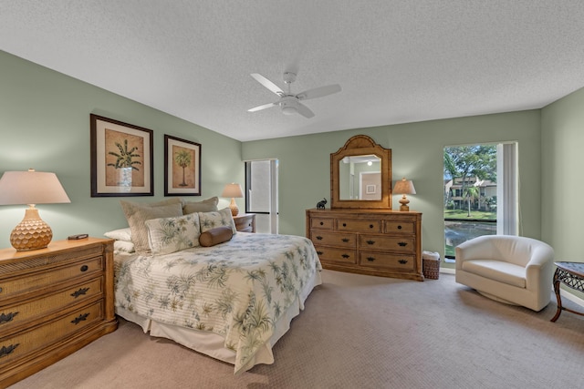 bedroom with light carpet, ceiling fan, and a textured ceiling