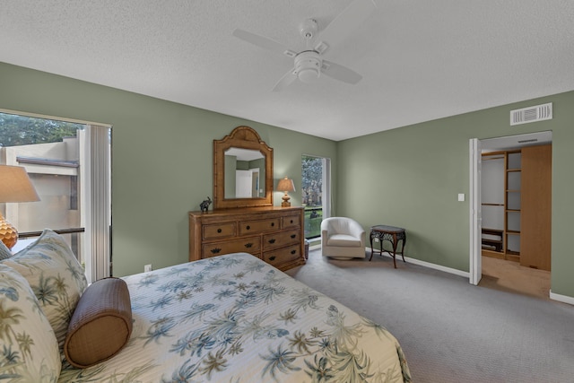 carpeted bedroom with a ceiling fan, baseboards, visible vents, and a textured ceiling