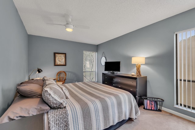 bedroom featuring a textured ceiling, carpet floors, ceiling fan, and baseboards