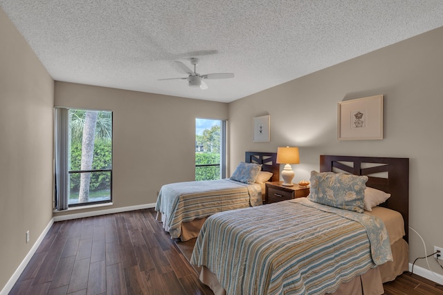 bedroom featuring a textured ceiling, baseboards, and wood finished floors