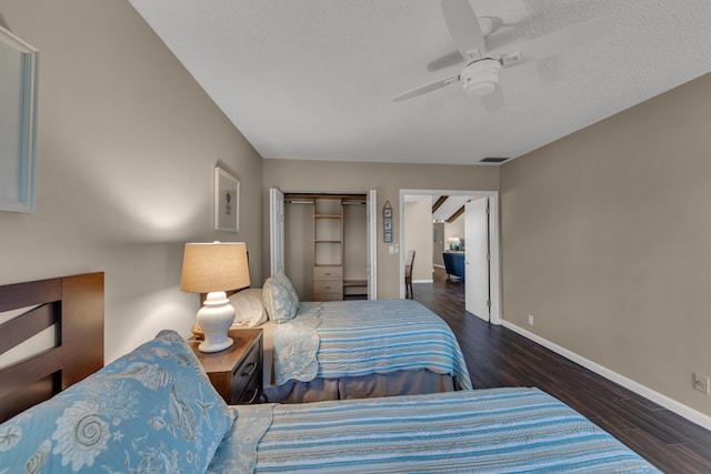 bedroom with ceiling fan, a textured ceiling, wood finished floors, visible vents, and baseboards