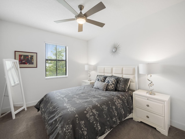bedroom with dark colored carpet, baseboards, and ceiling fan