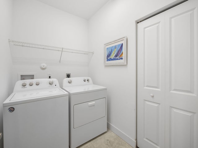 laundry room featuring washing machine and clothes dryer and baseboards