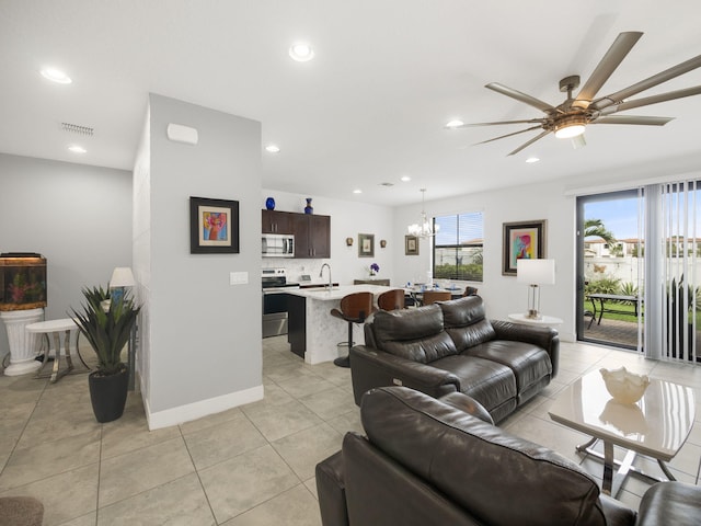 living area featuring ceiling fan, a chandelier, recessed lighting, light tile patterned floors, and baseboards