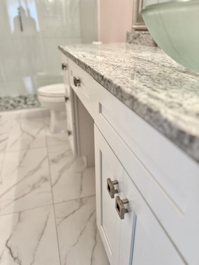 10694 Ocean Palm Way Unit 202, Boynton Beach, FL 33437 - full bathroom with vanity, marble finish flooring, toilet, and a shower