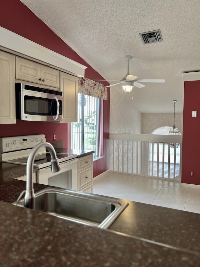 10694 Ocean Palm Way Unit 202, Boynton Beach, FL 33437 - kitchen featuring stainless steel microwave, a sink, lofted ceiling, a ceiling fan, and a textured ceiling