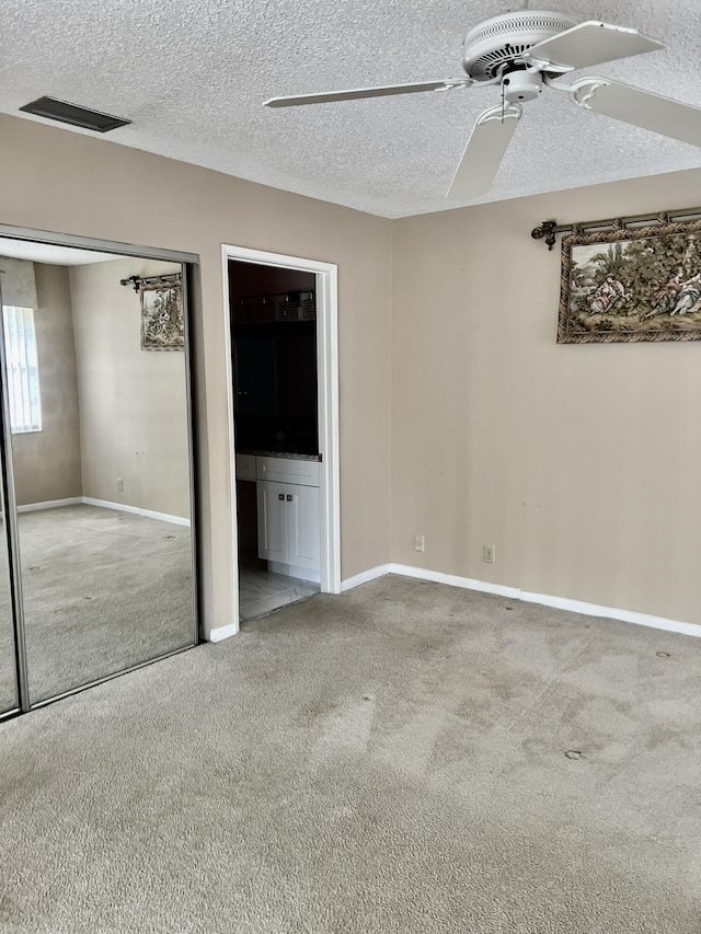 10694 Ocean Palm Way Unit 202, Boynton Beach, FL 33437 - unfurnished bedroom with carpet floors, baseboards, a textured ceiling, connected bathroom, and ceiling fan
