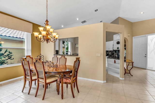 dining room featuring visible vents, arched walkways, a chandelier, and baseboards