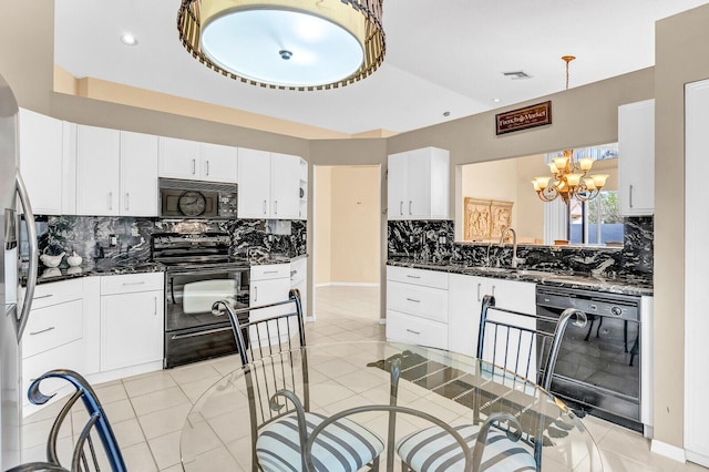 kitchen featuring white cabinets, an inviting chandelier, black appliances, pendant lighting, and a sink