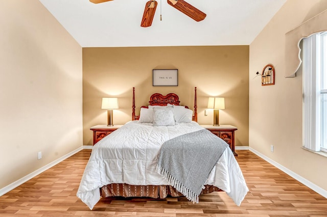 bedroom with baseboards, ceiling fan, and light wood-style floors