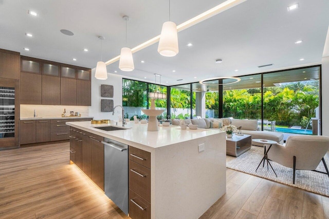 kitchen featuring light wood-type flooring, dishwasher, modern cabinets, and a sink