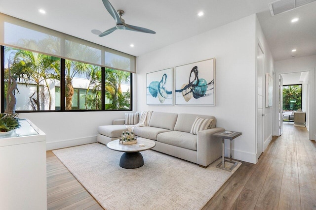 living room with recessed lighting, baseboards, visible vents, and light wood finished floors