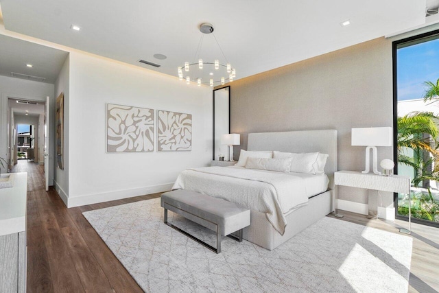 bedroom with baseboards, visible vents, a chandelier, and wood finished floors