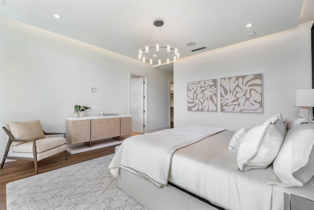 bedroom with visible vents and wood finished floors