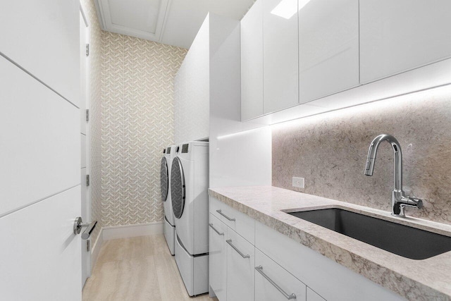 laundry area with cabinet space, a sink, and separate washer and dryer