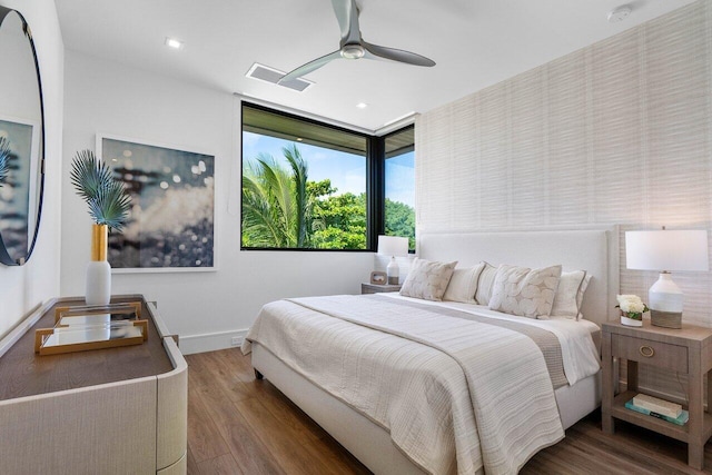 bedroom featuring baseboards, visible vents, ceiling fan, and wood finished floors