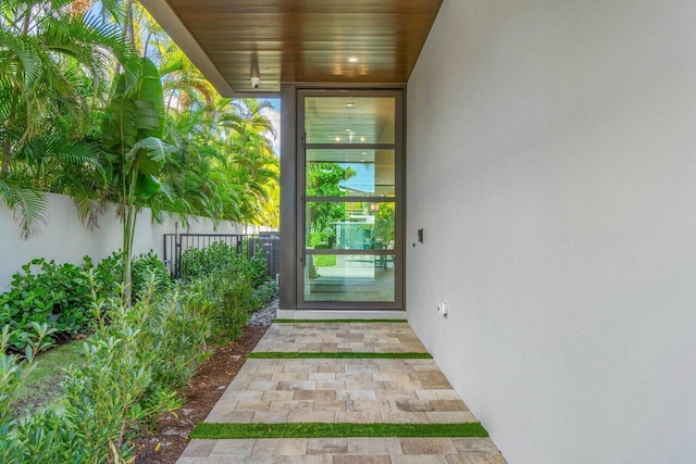 entrance to property with fence and stucco siding