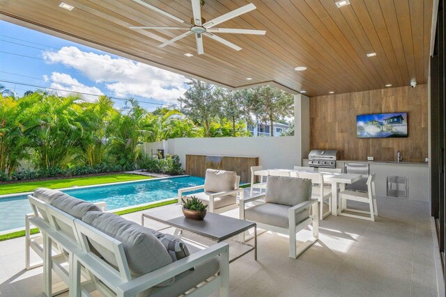 view of patio / terrace featuring a fenced in pool, an outdoor hangout area, exterior kitchen, and area for grilling