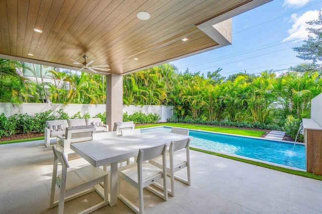 view of patio with a ceiling fan, outdoor dining space, a fenced in pool, and a fenced backyard