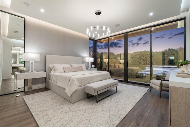bedroom with an inviting chandelier, visible vents, access to exterior, dark wood-type flooring, and expansive windows