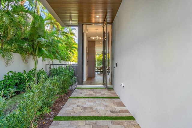 view of exterior entry featuring fence and stucco siding