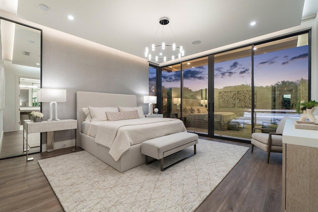 bedroom with a notable chandelier, wood finished floors, visible vents, and access to exterior