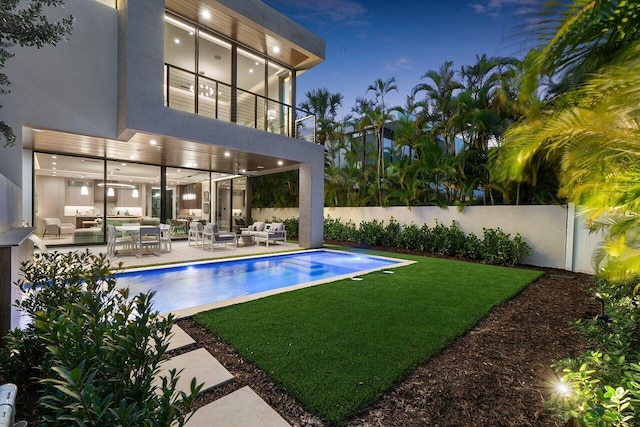view of swimming pool featuring a lawn, a fenced backyard, an outdoor hangout area, and a fenced in pool