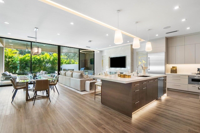 kitchen featuring wood finished floors, light countertops, a sink, and modern cabinets