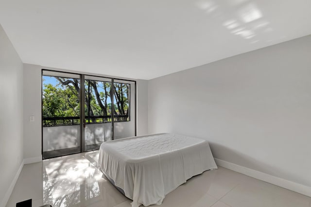 bedroom with light tile patterned floors and baseboards