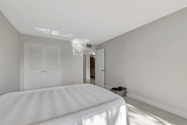 bedroom with a closet, visible vents, and baseboards