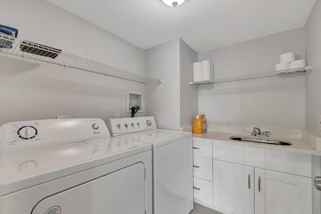 laundry room featuring washer and clothes dryer, a sink, and cabinet space