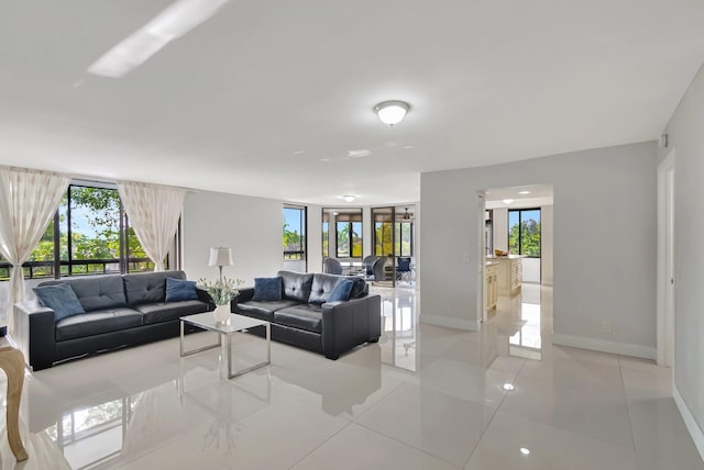 living room featuring a healthy amount of sunlight, light tile patterned floors, and baseboards