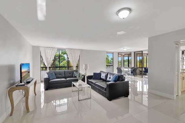 living room featuring light tile patterned floors, baseboards, and a wall of windows