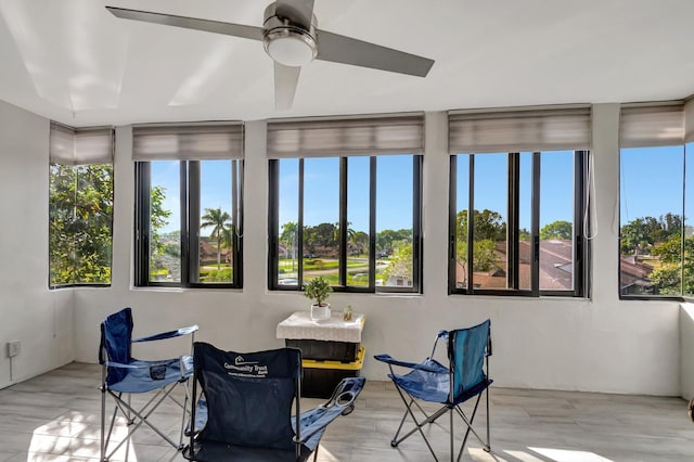 sunroom / solarium featuring a ceiling fan